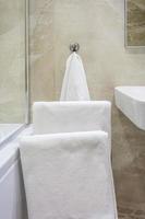 serviettes blanches sur un cintre dans la salle de bain photo