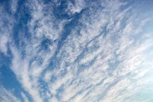 fond de ciel bleu avec de minuscules nuages rayés stratus cirrus. jour de dégagement et beau temps venteux photo