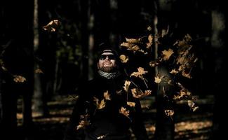 homme jetant des feuilles d'automne photo