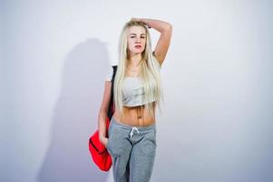 fille sportive blonde avec grand sac de sport posé au studio sur fond blanc. photo