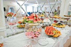 belle barre chocolatée de mariage avec des bonbons, des fruits et de la nourriture. table de banquet de mariage photo