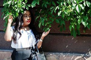 élégante femme d'affaires afro-américaine avec sac à main dans les rues de la ville. photo