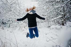 fille blonde s'amusant avec la neige le jour de l'hiver. photo