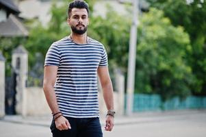 beau grand modèle d'homme à barbe arabe à chemise dépouillée posé à l'extérieur. mec arabe à la mode. photo