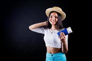 portrait d'une femme heureuse posant avec passeport et chapeau. photo