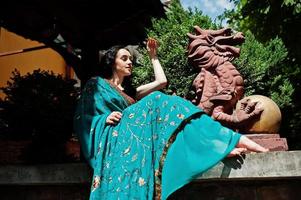 portrait d'une belle fille de brumette indienne ou d'un modèle de femme hindoue contre une maison traditionnelle japonaise et une figure de dragon. photo