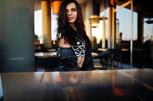 jeune femme frisée en blouson de cuir dans un bar. photo