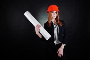 ingénieur femme en orange protéger casque avec projet de papier de construction. photo