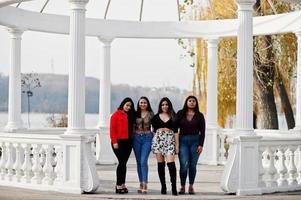 groupe de quatre filles latinos heureuses et jolies de l'équateur posées dans la rue contre l'ancienne arche. photo