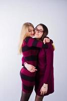 portrait de deux amies en robes de cerise posant en studio. photo