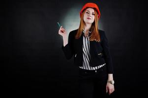 femme ingénieur en casque de protection orange avec pensil. photo