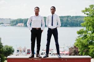 groupe de deux hommes d'affaires afro-américains posés dans la rue de la ville. photo