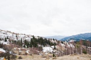 vallées de montagne enneigées dans les carpates. vue sur les carpates ukrainiennes et yaremche depuis le sommet de makovitsa. photo