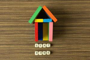 restez à la maison sur un cube en bois et un jouet à la maison pour un contenu de distanciation sociale. photo