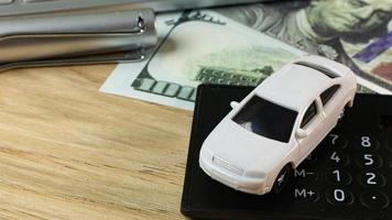 petite voiture blanche sur la table du poste de travail au bureau. photo