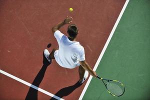 jeune homme jouer au tennis en plein air photo