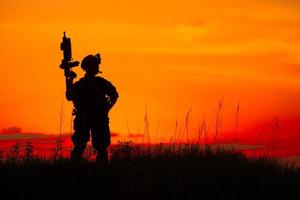 silhouette de soldat militaire ou officier avec des armes au coucher du soleil