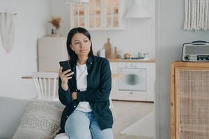 jeune femme pensive appréciant la musique en écoutant des airpods. fille dans les écouteurs se détendre et rêver. photo