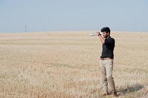 Agriculteur agronome sud-asiatique inspectant une ferme de champs de blé. notion de production agricole. photo