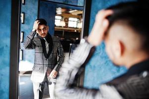 jeune homme d'affaires indien beau en costume de soirée au restaurant en regardant le miroir. photo