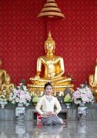 une femme portant des vêtements thaïlandais honorant le symbole sawasdee. photo
