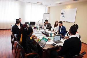 jeunes créatifs multiraciaux dans un bureau moderne. groupe de jeunes gens d'affaires travaillent avec un ordinateur portable, une tablette. équipe de pigistes à succès dans le coworking. photo