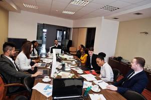 jeunes créatifs multiraciaux dans un bureau moderne. groupe de jeunes gens d'affaires travaillent avec un ordinateur portable, une tablette. équipe de pigistes à succès dans le coworking. photo