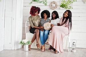 quatre meilleurs amis. jeunes femmes africaines s'amusant, assises sur le canapé rétro. photo