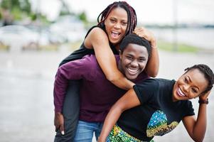 trois amis afro-américains s'amusant ensemble. sauter sur l'épaule. photo