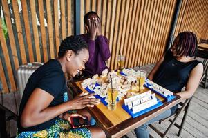 groupe de trois amis afro-américains jouent à des jeux de table. photo