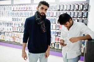 deux indiens mans client acheteur au magasin de téléphonie mobile avec eux de nouveaux smartphones. concept de peuples et de technologies d'asie du sud. magasin de téléphonie mobile. photo