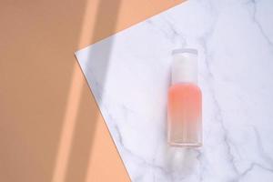 mise à plat de produit de soin de la peau sur fond de marbre et orange dans un style minimal avec forme d'ombre, produit de beauté et de soins de santé photo