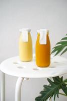 jus pressé à froid de citrouille et d'ananas dans une maquette de bouteille avec étiquette vierge pour une boisson saine avec vitamines et antioxydants, mode de vie végétalien