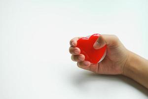 une femme tenant un coeur rouge à la main sur une idée de don de fond blanc photo