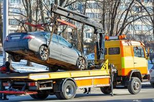 le travail d'une dépanneuse de voiture dans une rue de la ville par une journée ensoleillée d'hiver. photo