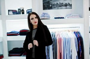 fille magnifique brune dans la boutique du magasin de vêtements à des vêtements décontractés. photo