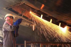 un soudeur travaillant une torche au chantier naval photo