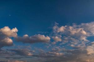 fond de ciel bleu foncé avec de minuscules nuages rayés stratus cirrus. soirée dégagée et beau temps venteux photo