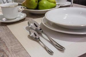 table dans la cuisine avec assiettes de verres et poires vertes photo