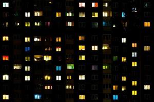 panorama nocturne plat de lumière multicolore dans les fenêtres des bâtiments à plusieurs étages. la vie dans une grande ville photo