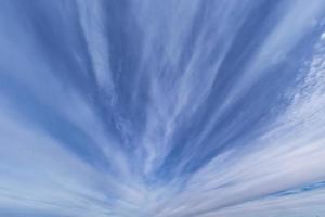 fond de ciel bleu foncé avec de minuscules nuages rayés stratus cirrus. soirée dégagée et beau temps venteux photo