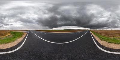 panorama hdri sphérique complet et harmonieux vue d'angle à 360 degrés sur la route goudronnée parmi les champs en automne avec de beaux nuages avant la tempête en projection équirectangulaire, prêt pour le contenu vr ar photo