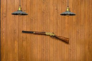 deux lampes vintage et fusil de chasse sur un mur en bois photo