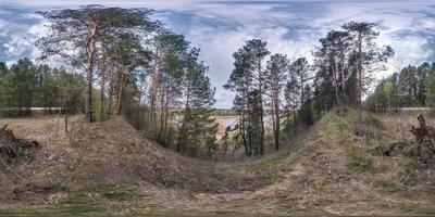 panorama hdri sphérique complet et harmonieux vue à 360 degrés sur la haute côte de la large rivière dans la forêt de pins au printemps en projection équirectangulaire, prêt pour le contenu de réalité virtuelle ar vr photo