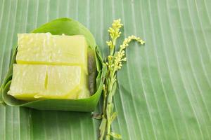 sorte de sucrerie thaïlandaise, gâteau sucré multicouche kanom chan sur feuille de bananier avec fleur d'orchidée photo