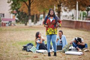 groupe de cinq étudiants africains qui passent du temps ensemble sur le campus de la cour universitaire. amis afro noirs qui étudient. thème de l'éducation. photo