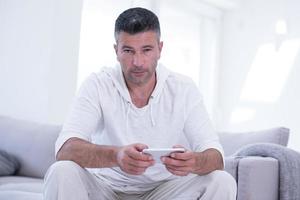 jeune homme utilisant un téléphone portable à la maison photo