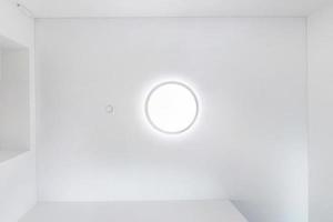 regardant vers le haut sur un plafond suspendu avec des lampes halogènes et une construction de cloisons sèches dans une pièce vide d'un appartement ou d'une maison. plafond tendu de forme blanche et complexe. photo