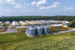 vue aérienne sur les silos et le complexe d'élevage agro-industriel sur l'agro-industrie et l'usine de fabrication avec élévateur à grains moderne. élevage de poulets. rangées de poulailler photo