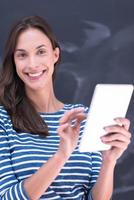 femme utilisant une tablette devant une planche à dessin à la craie photo